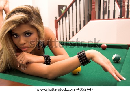 Sexy young Asian bikini model laying on her belly on top of a pool table
