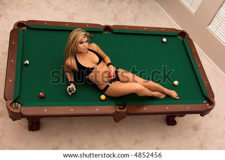 Sexy young Asian bikini model laying on top of a pool table