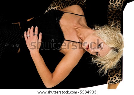 Pretty blonde fashion model with short blond hair laying on a black and leopard print couch
