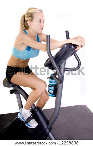 young blonde woman riding a stationary bike in the gym