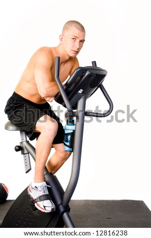 Young man riding a stationary bike in the gym