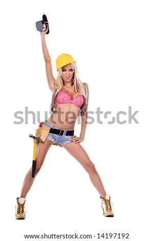 High fashion glamour model in Daisy duke shorts, tool belt, pink bra and yellow hard hat with a screw gun and high heel work boots