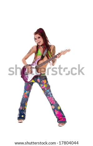 Heavily tattooed young hippie rocker woman in retro patchwork jeans and bikini top with long red dreadlocks playing electric guitar