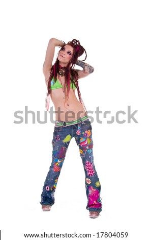 Heavily tattooed young hippie woman in retro patchwork jeans and bikini top with long red dreadlocks