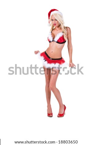 Sexy blonde dressed as Mrs. Santa in a short fur trimmed skirt and bra top in red patent leather high heels with her finger to her cheek pondering Christmas