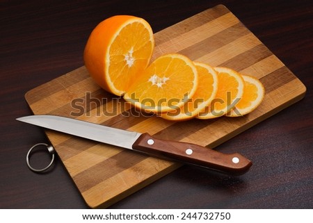 Cutting of ripe juicy orange on a chopping board