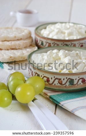 Diet breakfast: crispbread, green grapes and cottage cheese in ceramic ware hand-painted
