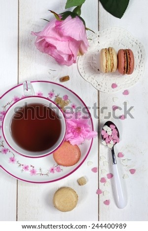 Valentine\'s Day: Romantic tea drinking with macaroon and hearts and and pink flowers