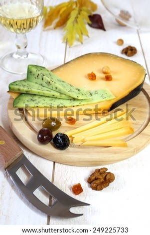 Cheese platter: solid cheese, Provencal olives, walnuts and glass of white wine