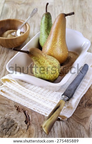 Three pears Conference in ceramic baking dish, brown sugar and vintage knife