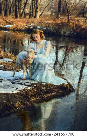 Portrait of romantic woman in vintage dress on the river bank
