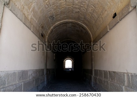 Tunnel with light in the end inside historic building