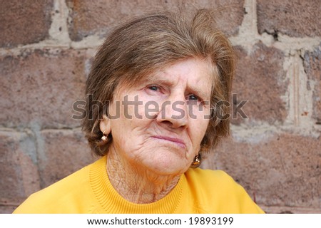 Sad old woman in the yellow blouse