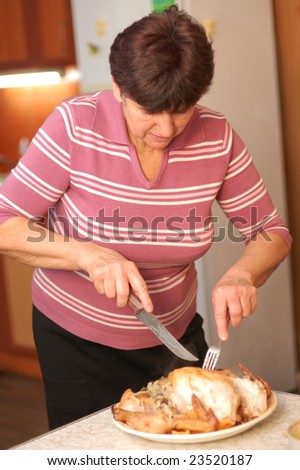 Woman parts fried chicken at kitchen