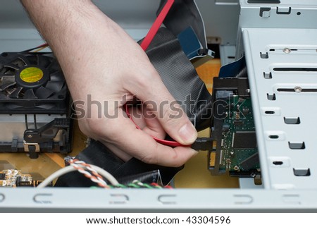 Man hand  assembles computer cable into system unit
