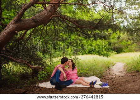 Pregnant woman and her husband\
\
family waiting for baby. Picnic in the wood