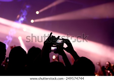 A rave and many hands with cell phones and cameras taking pictures, party, concert or rave concept