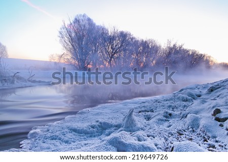 Winter landscape with frosty sunrise and winter river at very cold weather.