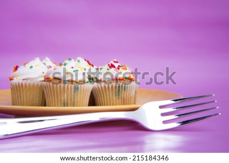 Mini cupcakes on yellow plate with fork