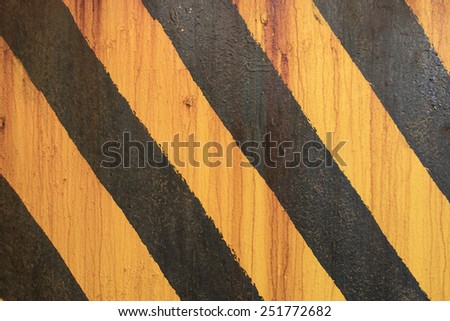 Yellow and black painted wall with rusting screws