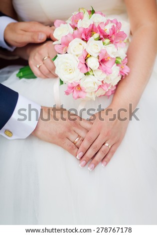 Wedding couple holding hands with a bouquet of flowers
