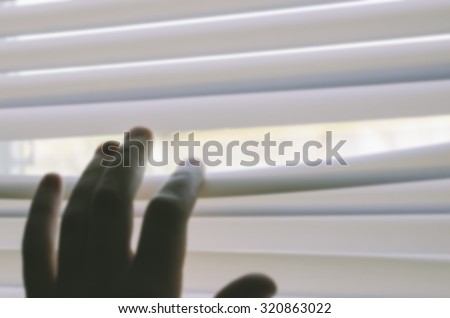 Blurred defocused photo of the people hand on the curtains abckground