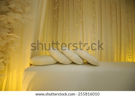 A few pillow on a white bench for a wedding decorations