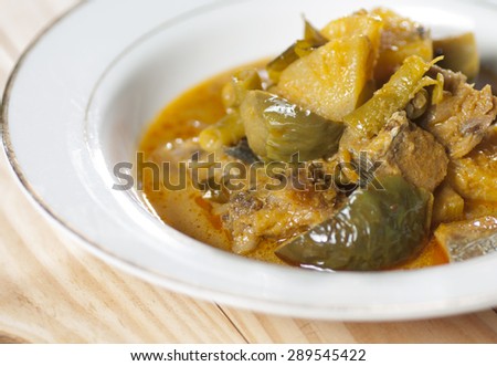 red curry with salted fish in bowl on pine wood background