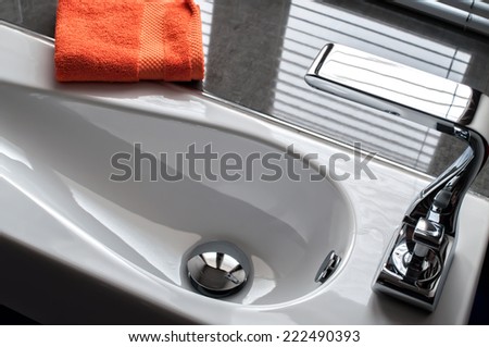 Contemporary wash hand basin with orange towel