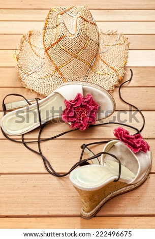 Straw sun hat and sandals on cedar deck
