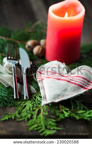 Celebration with special cutlery and a candle. Composition of cutlery on wood background fir branches and a decorative star and christmas balls for romantic evenings or family celebrations