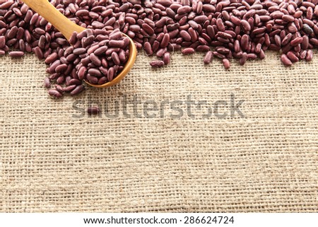 Red beans seen from above pouch of jute illuminated with natural light