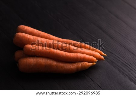 fresh carrots on a black wooden background