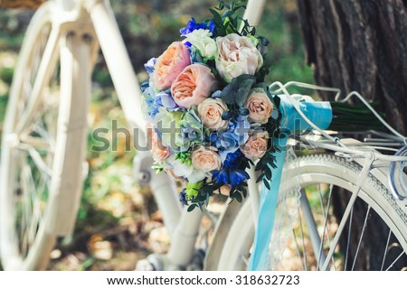 Wedding bouquet of bride - colorful flowers pink, white roses and blue freesia and hydrangea at wedding on nature
