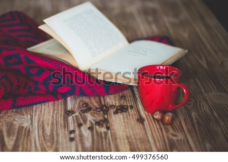Cup of coffee and books on tablecloth on wooden background