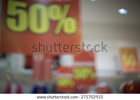 Sign of 50 percent discount in blurry image at shopping mall