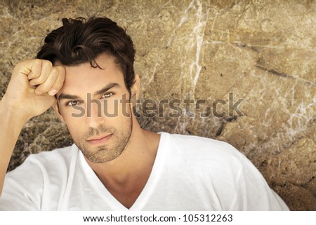 Portrait of young man outdoors with very handsome face in white casual shirt against natural background