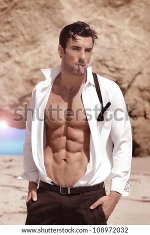 Sexy handsome playboy outdoors with shirt open revealing hot body and nice abs