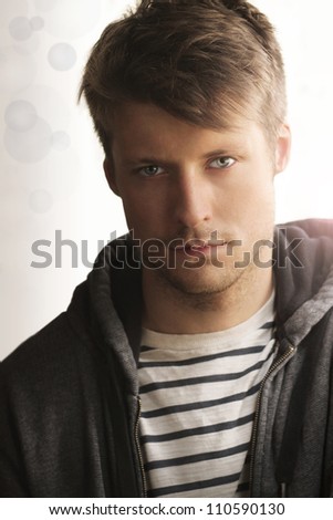 Portrait of young man handsome face and trendy clothing against modern abstract background