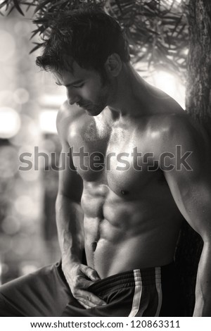 Sexy sensual outdoor portrait of a very fit male model shirtless showing abs