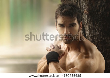 Outdoor portrait of a muscular shirtless hot guy with copy space