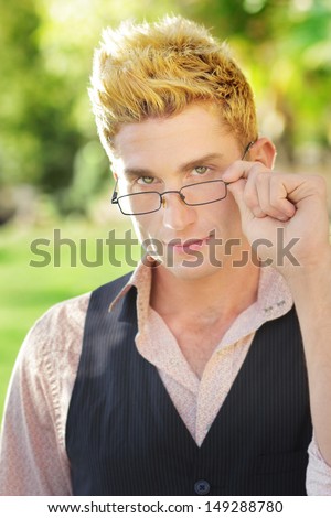 Quirky young man portrait in glasses outdoors