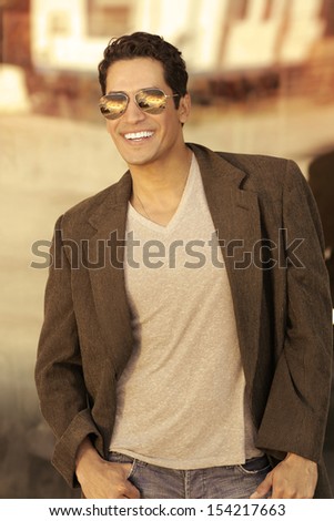 Portrait of a sexy young man in sunglasses with big smile