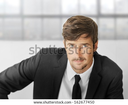 Bright portrait of an attractive smart young businessman in modern office setting