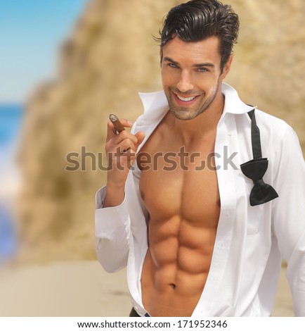 Sexy muscular handsome man with big smile and open shirt holding cigar