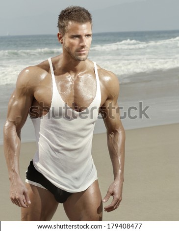 Sexy muscular male model on the beach in warm summer light