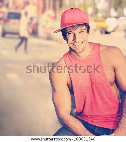 Portrait of a happy cute young guy smiling on the street with overall vintage toning and styling