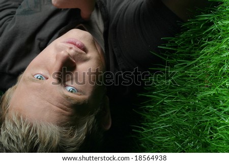 night photo of blond guy laying on grass