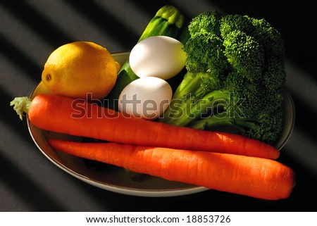 Colorful food on a plate in natural light with black background