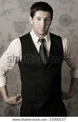 Full body portrait of young stylish businessman in tie and vest with hands on waist